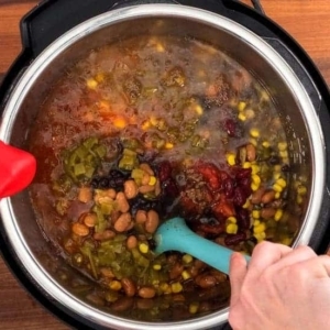 mixing instant pot taco soup with ground beef, beans, and vegetables