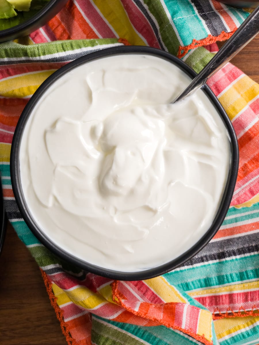 a bowl of sour cream served alongside taco soup