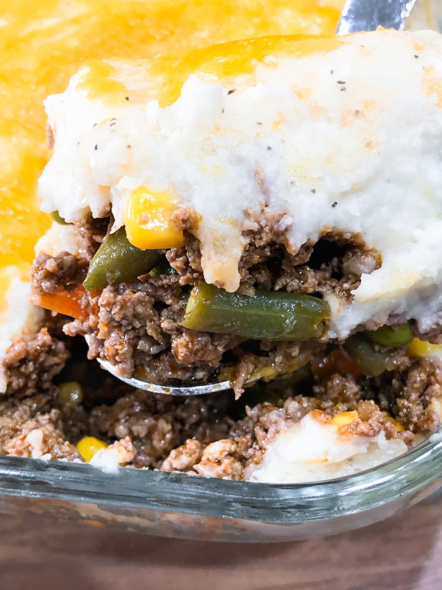 a large spoonful of shepherds pie from a serving bowl