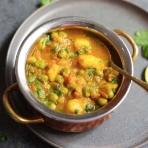 aloo matar potatoes and peas in a small pot bowl