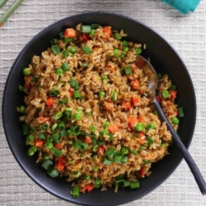 overhead shot of brown fried rice in a bowl garnished with scallions