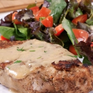 close up shot of smothered pork chops lightly garnished with cilantro