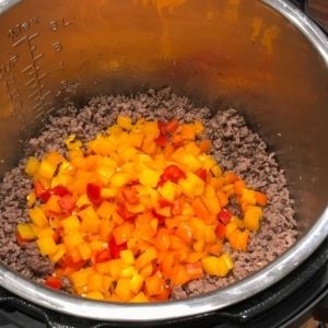 adding diced colorful peppers to ground sirloin