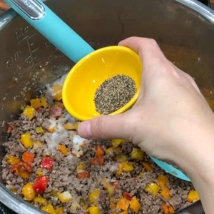 adding black pepper to season ground beef for couscous