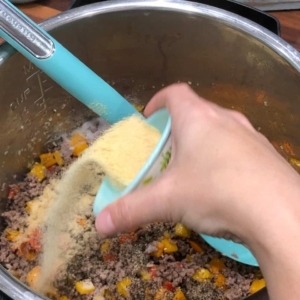 adding garlic powder to season couscous