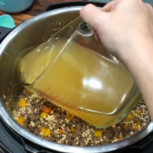 adding chicken broth to the couscous