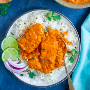 overhead shot of a plate of salmon tikka masala garnished with cilantro