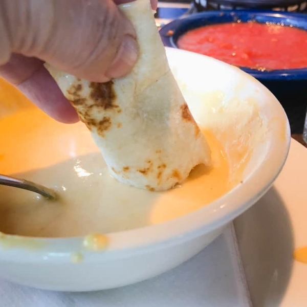 dipping fresh tortillas in queso at alamo cafe san antonio tx