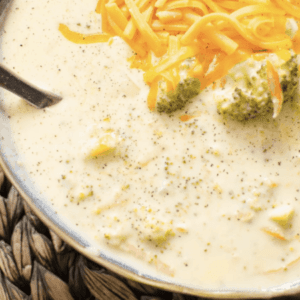 overhead shot of broccoli cheese soup topped with shredded cheese