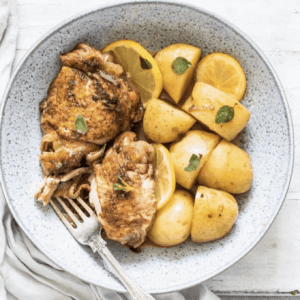 overhead shot of chicken and potatoes garnished with lemon slices