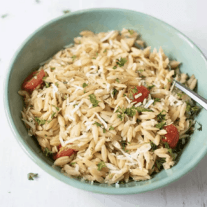 lemon parmesan orzo in a bowl topped with shredded parmesan