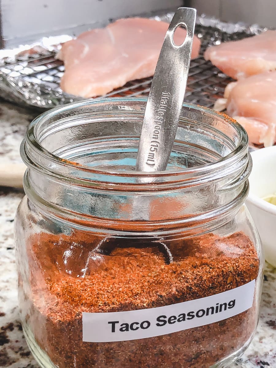 a tablespoon inside an open jar of taco seasoning