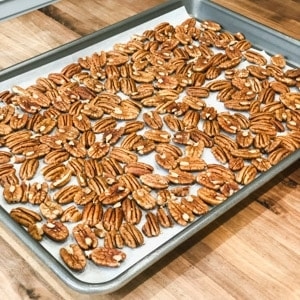 spreading pecans in a baking sheet