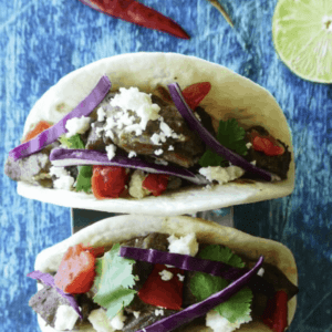 two carne asada tacos on a taco holder stand