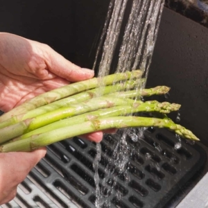 rinsing asparagus spears under cool water