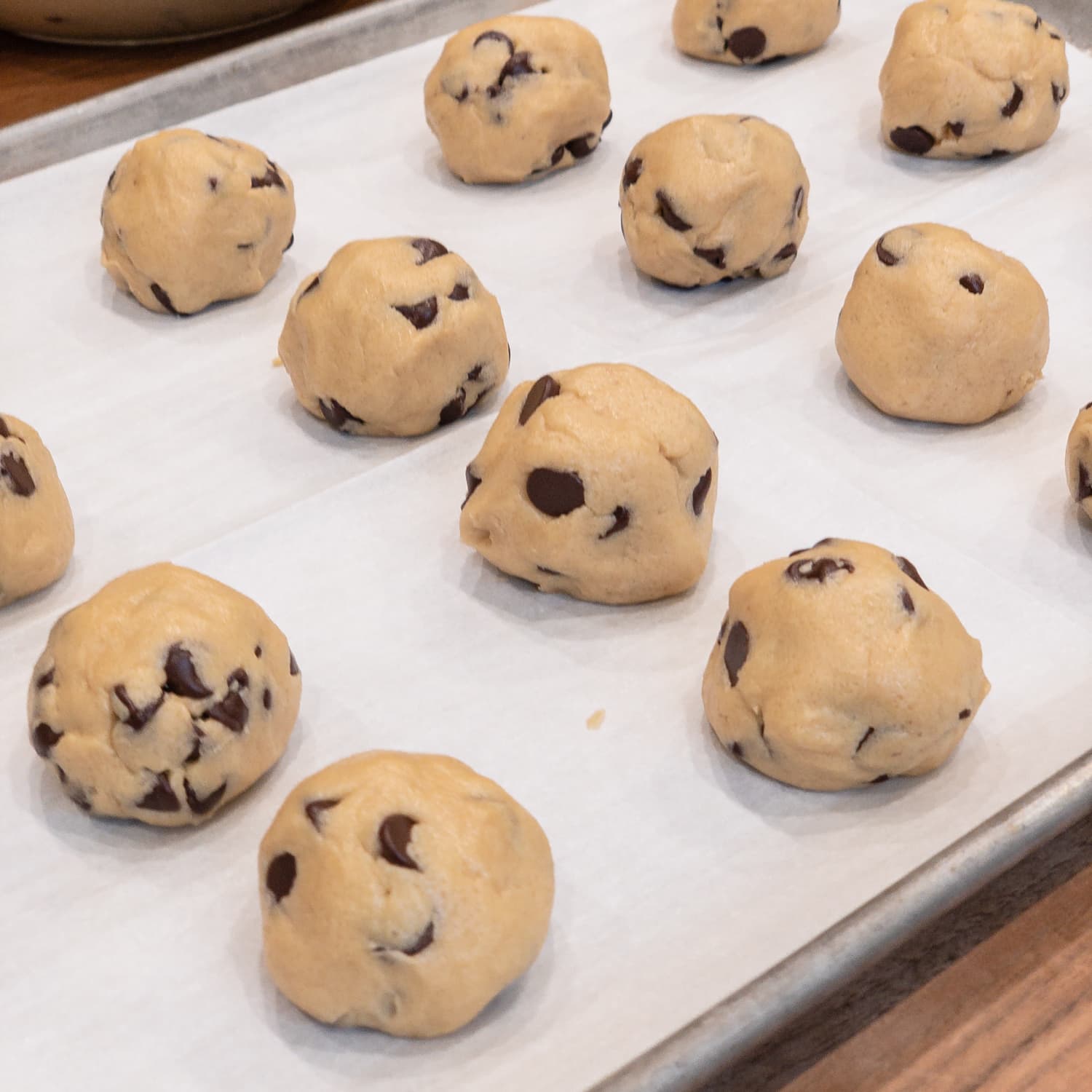 chocolate chip cookie dough balls sitting on a baking sheet