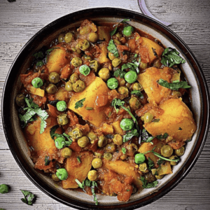 overhead shot of aloo matar in a bowl garnished with cilantro