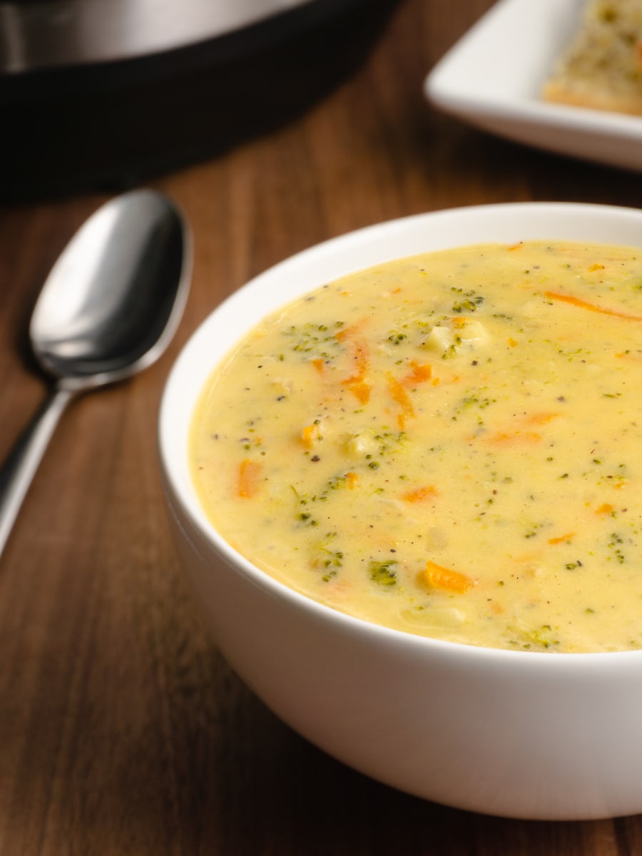 half shot of a bowl of broccoli cheddar soup