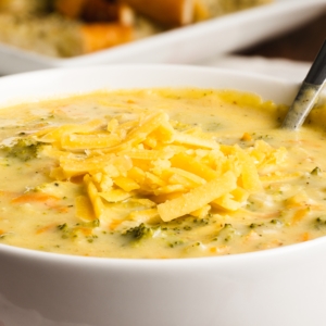 a bowl of broccoli cheese soup topped with shredded cheese