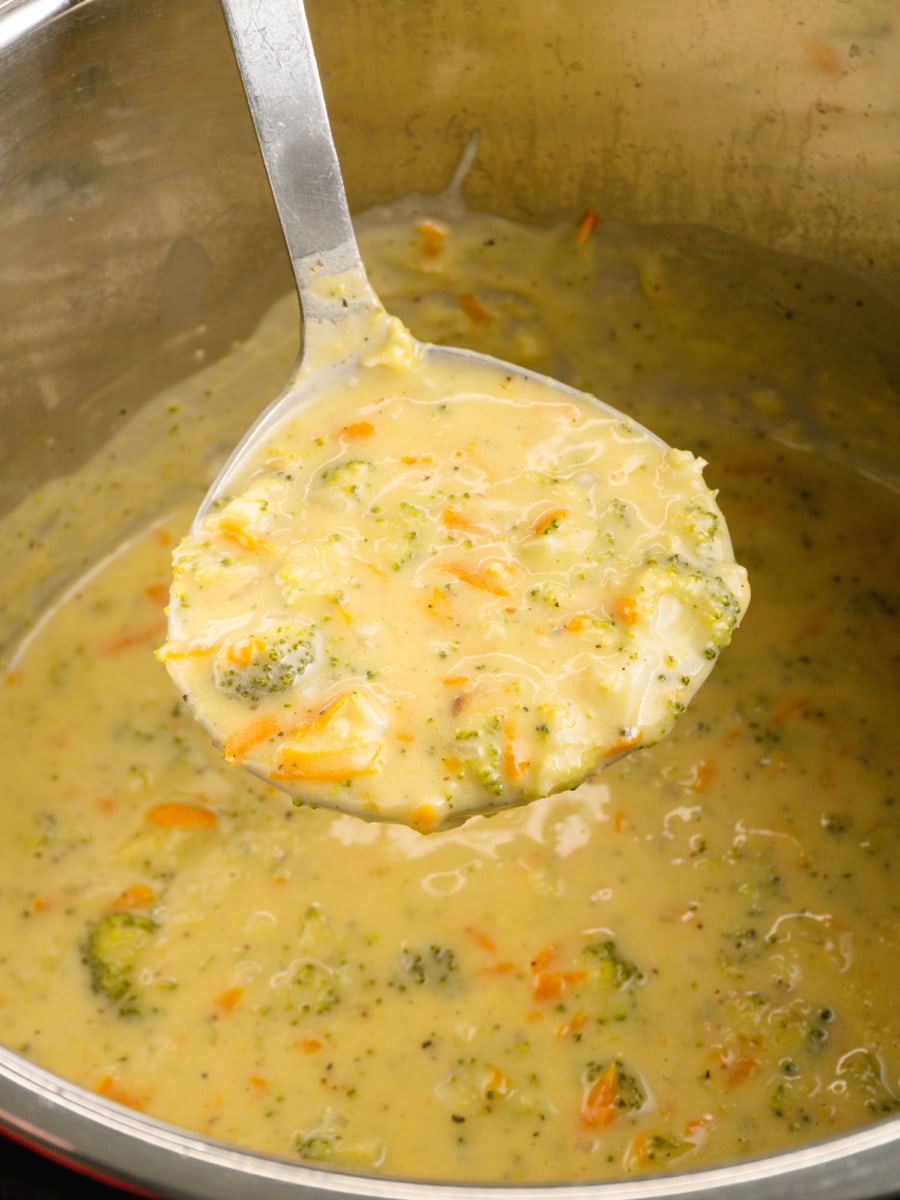 a ladle of cheddar broccoli soup over the instant pot