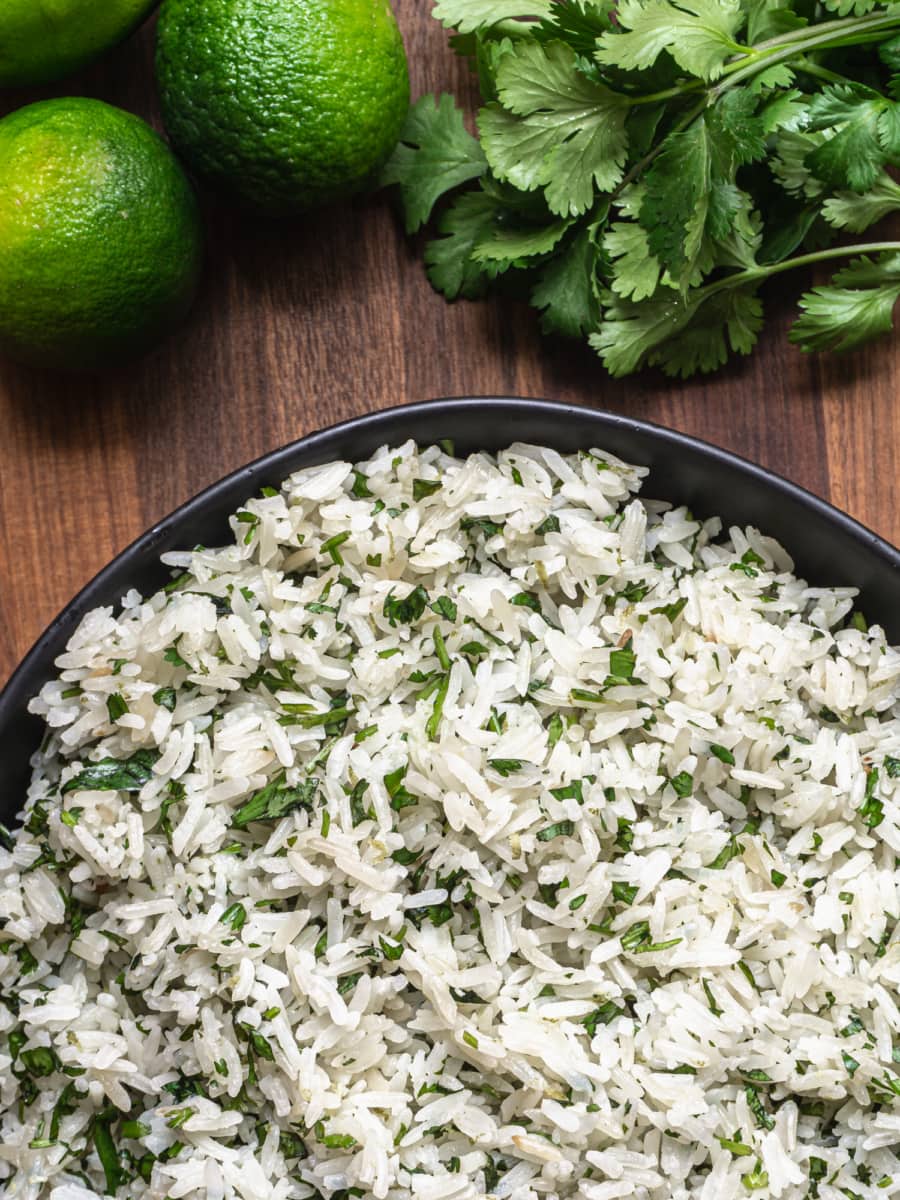 overhead shot of lime and cilantro with a bowl of cilantro lime rice