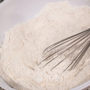 mixture of flour, cornstarch, baking powder, baking soda, and salt in a bowl with a whisk