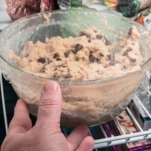 placing a covered bowl of chocolate chip cookie dough in the freezer