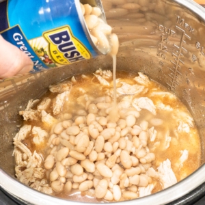 adding great northern beans to the instant pot for making white chicken chili