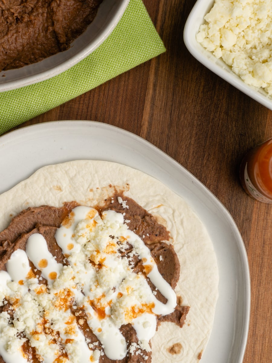 authentic refried beans spread on a flour tortilla to make a baleada