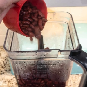 adding red beans to a blender