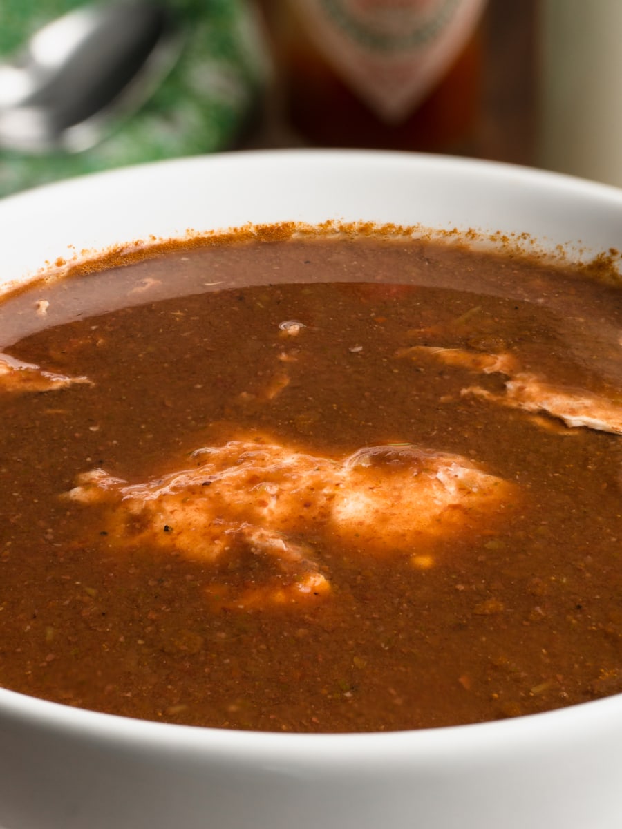 close up of bean soup with a poached egg served in a bowl