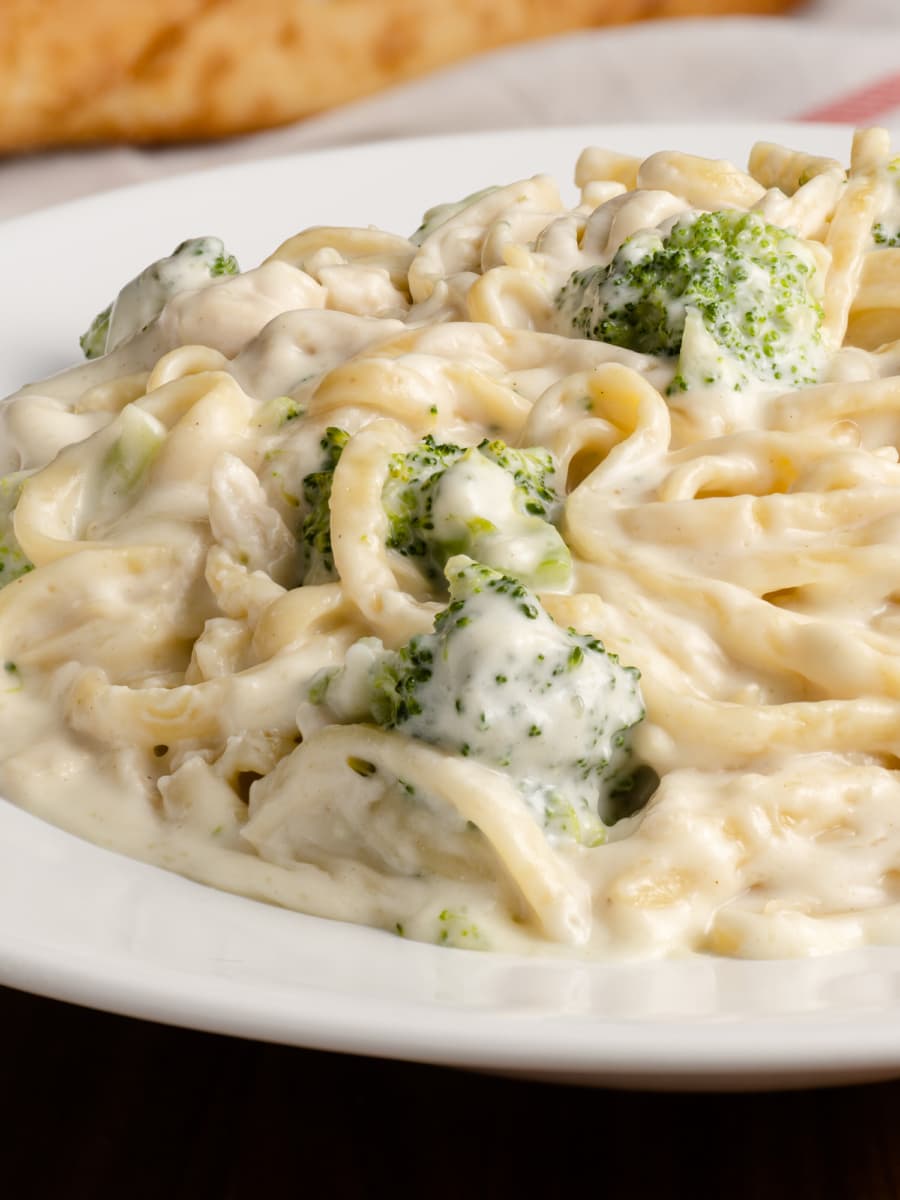 a plate of chicken and broccoli alfredo