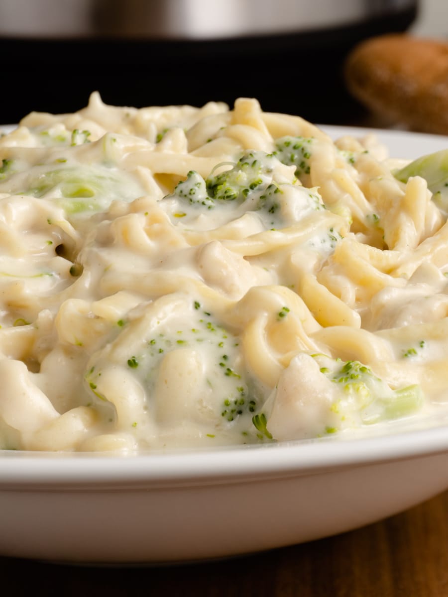 a plate of chicken broccoli alfredo with fettucine