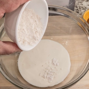 adding all-purpose flour to heavy cream to make an alfredo sauce