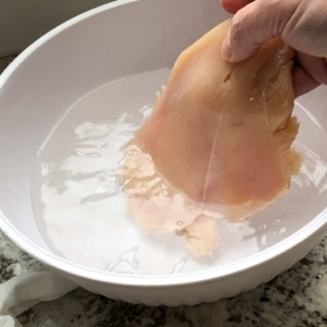 adding chicken breasts to the brine