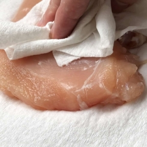 patting the chicken breasts dry with paper towel