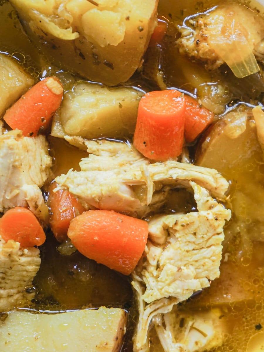 Turmeric spiced Instant Pot Chicken Soup with baby carrots and potatoes.