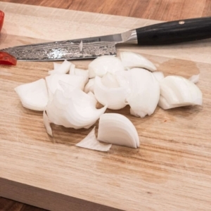 rough cut onion on a wooden board