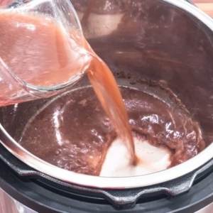 adding four cups of bean broth to the pressure cooker