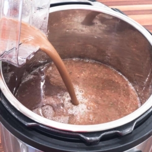 adding the blended red bean and vegetable mixture to the pressure cooker