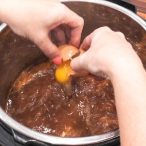 cracking egg into bean soup