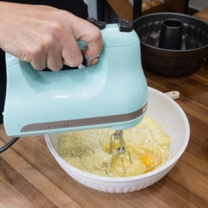 using a hand mixer to mix the ingredients for making a lemon cake batter from a box cake mix