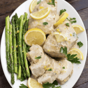 overhead shot of a plate of creamy lemon chicken garnished with cilantro and lemon slices