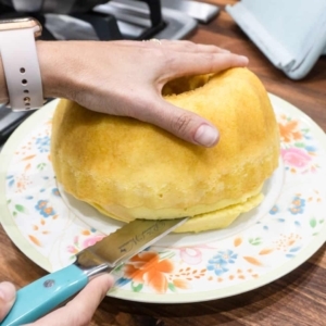 cutting the bottom of a bundt cake to make it sit level