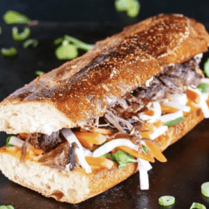 banh mi sandwich on a flat surface garnished with green onions