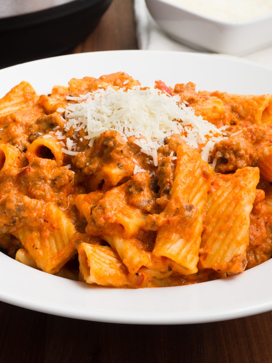 a white bowl with instant pot cheesy sausage rigatoni