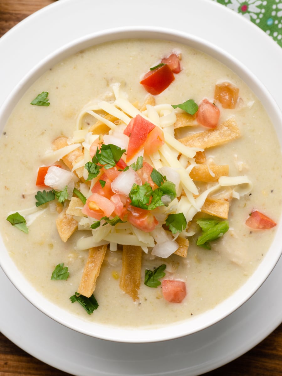 instant pot chicken enchilada soup topped with pico de gallo and shredded cheese