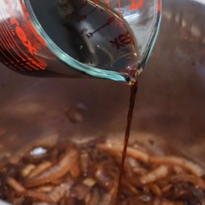 adding soy sauce to sautéed onions in the instant pot