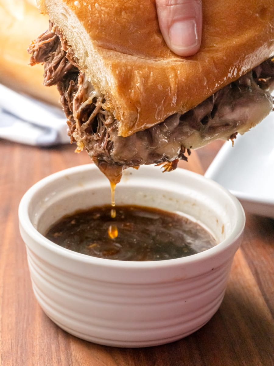 dipping a french dip sandwich in au jus