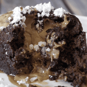 a cut open peanut butter lava cake topped with powdered sugar